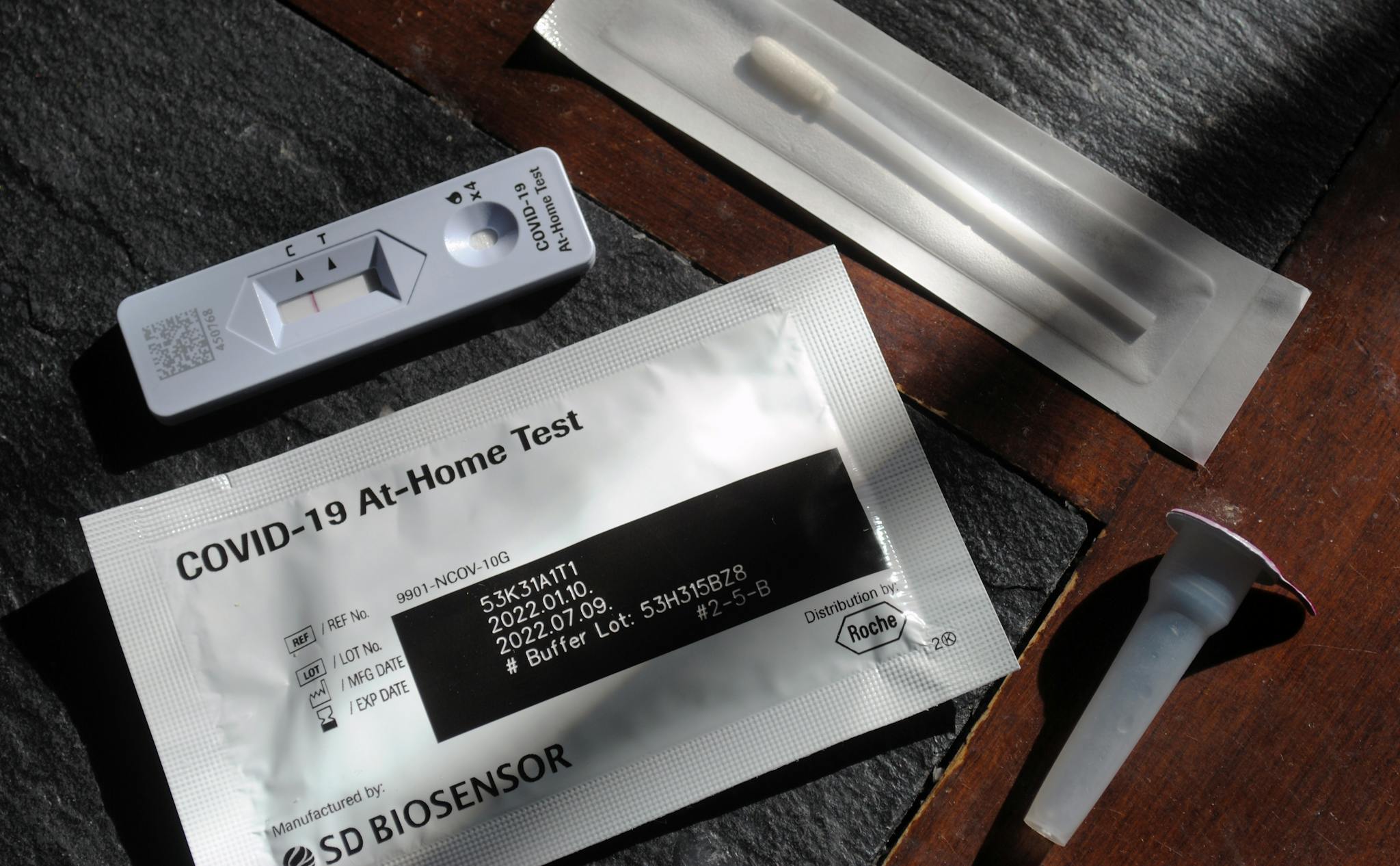 Close-up of a COVID-19 at-home test kit with packaging and test components displayed.