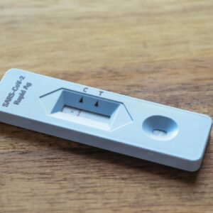 Close-up of a COVID-19 rapid antigen test on a wooden surface for health screening.