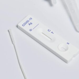 Close-up of a COVID-19 rapid antigen test kit showing the testing strip and swab.