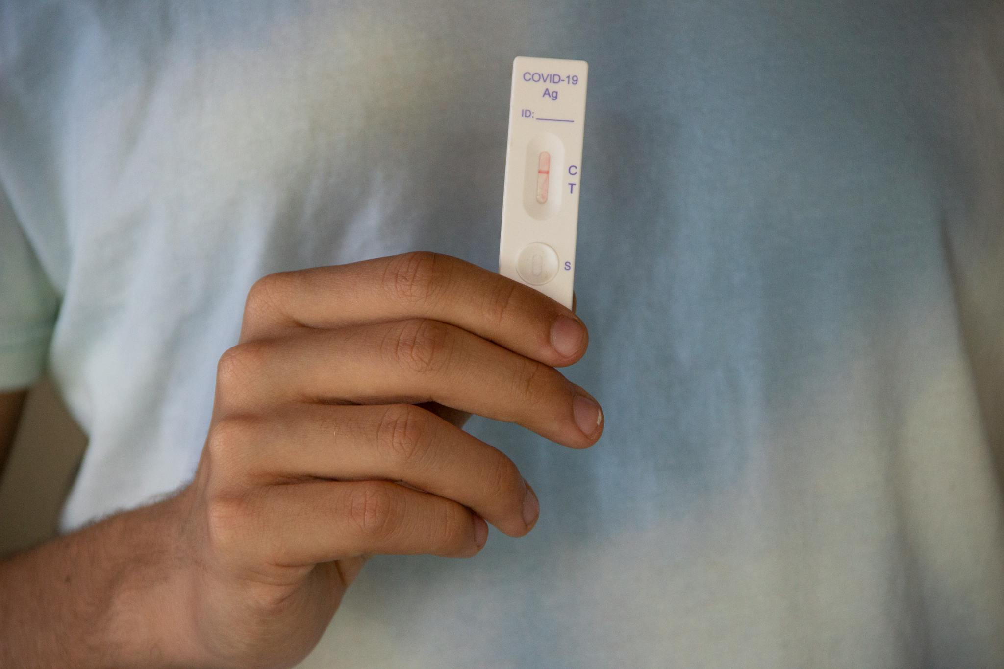 Close-up of a negative COVID-19 test result being held by an adult's hand, symbolizing hope and health.